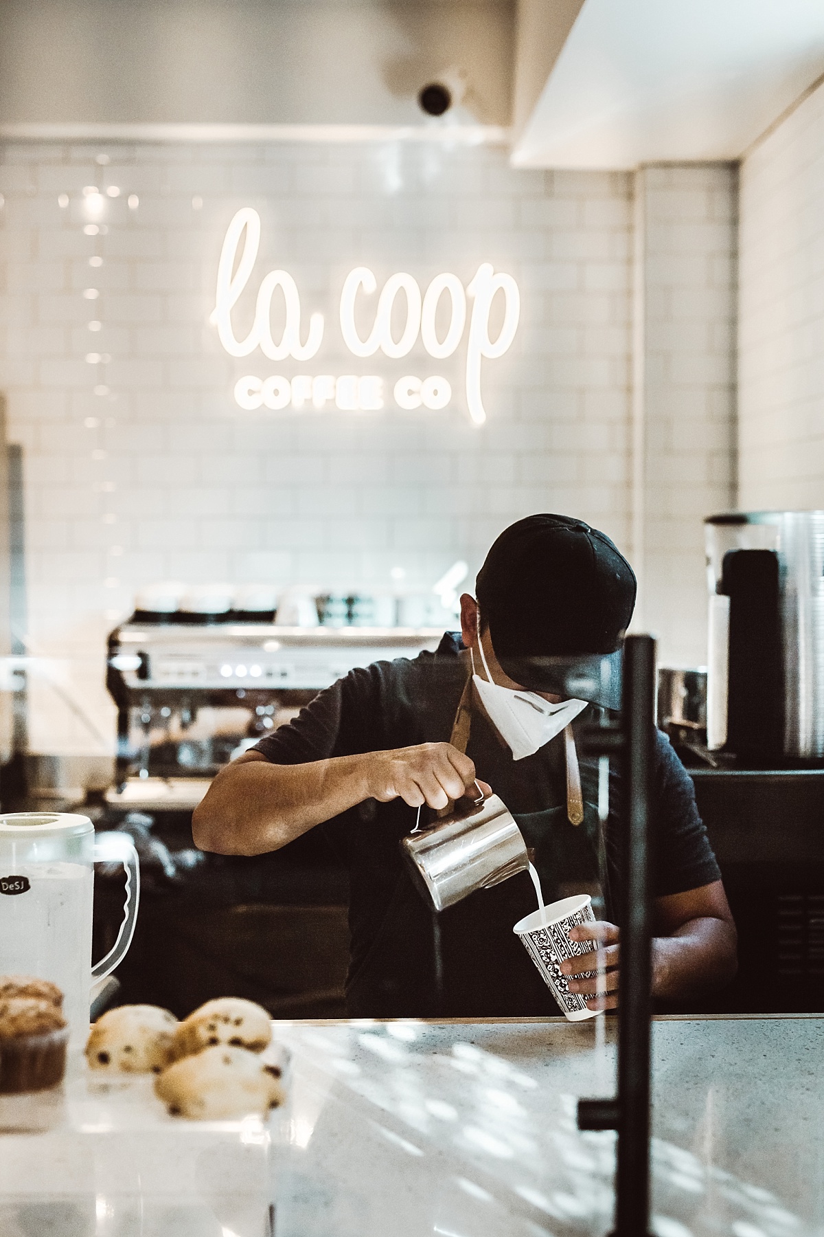 juan salazar pours steamed milk into cup at la coop coffee