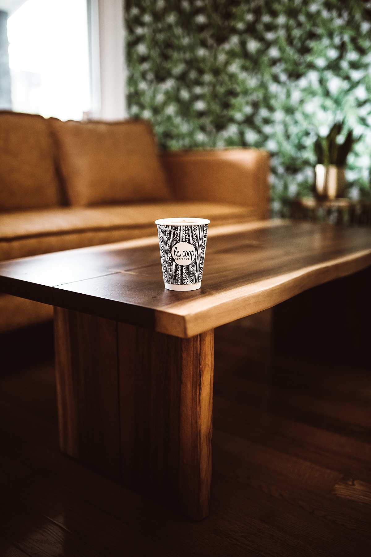 la coop coffee cup sits on gorgeous wood table at DC coffee shop
