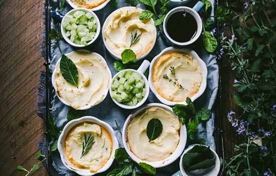 tray of lovely cottage pies with greenery, bay leaves, thyme, and rosemary