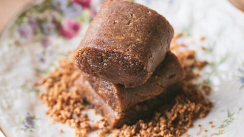 horizontal view of turron de jijona on decorative plate with crushed almonds