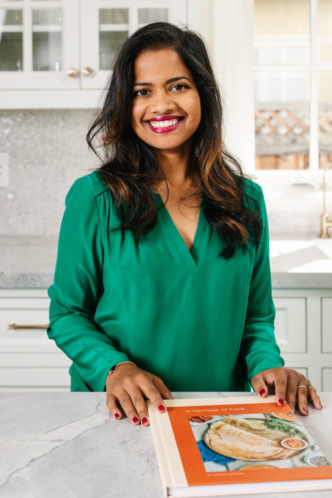 Sri Bodanapu owner of Heirloom Project custom family cookbooks poses with one of her products
