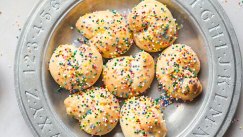 seven Anginetti cookies covered with sprinkles on a plate