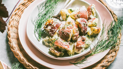 creamy chunks of red potatoes covered with dill cream sauce on pink plate