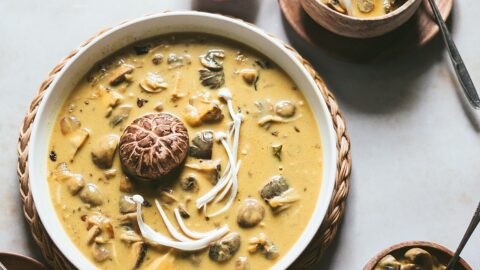 gorgeous golden bowl of golden creamy mushroom curry. Garnished with decorative enoki and portobello mushrooms