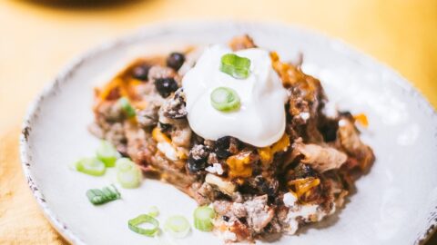 slice of Tex Mex Casserole, topped with a dollop of sour cream and green onions